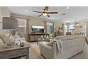 Open-concept living room with neutral colors, tile flooring, large TV, and natural lighting at 10136 Grand Oak Cir, Madeira Beach, FL 33708