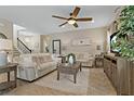 Spacious living room features tile floors, neutral colors, ceiling fan, and a stairway at 10136 Grand Oak Cir, Madeira Beach, FL 33708