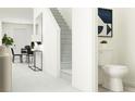 Hallway with a staircase, dining table, and a half bathroom with a toilet and mirror at 10807 Fort White Ct, Tampa, FL 33647