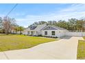 Long driveway leading to a pristine home with an expansive front yard at 11105 Mexican Canary Ave, Weeki Wachee, FL 34614