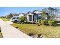 Landscaped single-story home features a well-manicured lawn, an attached garage, and a neutral exterior paint scheme at 12593 Palapa Loop, Spring Hill, FL 34610