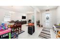 Bright living area with tile floors, neutral walls, a decorative front door, and large windows for natural light at 12593 Palapa Loop, Spring Hill, FL 34610