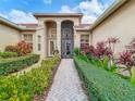 Beautiful home exterior featuring lush landscaping and a brick walkway to the front door at 16112 Amethyst Key Dr, Wimauma, FL 33598