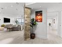 Open-concept living room featuring stone accent wall, tile flooring, and contemporary furnishings at 1660 Gulf Blvd # Ph2, Clearwater Beach, FL 33767