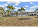 Back exterior view of a home with a screened-in porch and well-maintained lawn at 1740 Coco Palm Cir, Sun City Center, FL 33573