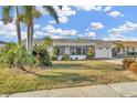 Attractive single-story home with lush tropical landscaping and inviting screened porch at 1740 Coco Palm Cir, Sun City Center, FL 33573