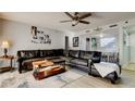 Living room featuring ceiling fan, dark sofa, open access to dining room, and light gray flooring at 200 Country Club Dr # 503, Largo, FL 33771