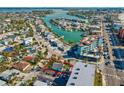 Aerial view of a property with a backdrop of a bay featuring docks and boats in a coastal neighborhood at 40 140Th E Ave, Madeira Beach, FL 33708