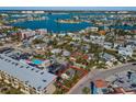 Aerial view showcasing property near a bay with boats, surrounded by residential buildings in a coastal community at 40 140Th E Ave, Madeira Beach, FL 33708