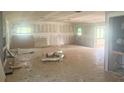 Large living room with unfinished drywall and visible window frames awaiting updates at 4004 27Th Se St, Ruskin, FL 33570