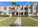 Inviting condo exterior with well-maintained landscaping, palm trees and visible unit number above the entrance at 5900 Bahia Del Mar Cir # 237, St Petersburg, FL 33715