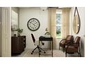Bright office with a dark desk, two chairs, decorations, and natural light from the window at 9452 Runaway Breeze Dr, Land O Lakes, FL 34637