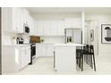 Modern kitchen with white cabinets, an island, and stainless steel appliances at 12649 Lily Quartz Loop, Parrish, FL 34219