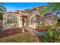 Inviting home featuring a well-manicured front yard with a stone walkway leading to the front door at 12816 Pacifica Pl, Tampa, FL 33625