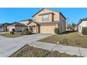 Two story house with a two car garage, well-maintained landscaping, and a concrete driveway on a sunny day at 14269 Lemon Yellow Tree Ln, Brooksville, FL 34613
