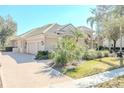 Charming home featuring a tile roof, three-car garage, and lush landscaping at 16331 Burniston Dr, Tampa, FL 33647