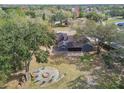 Expansive backyard with fire pit and seating area, surrounded by mature trees providing shade and privacy for outdoor gatherings at 16508 Round Oak Dr, Tampa, FL 33618