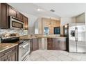 Modern kitchen featuring stainless steel appliances, granite countertops, dark wood cabinetry and mosaic tile backsplash at 16508 Round Oak Dr, Tampa, FL 33618