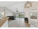 Bright living room with vaulted ceilings, tile flooring, a fireplace, and sliding glass doors to a spacious backyard at 16508 Round Oak Dr, Tampa, FL 33618