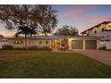 Charming single-story home featuring a manicured lawn, mature trees, and a two-car garage at 3961 12Th Ne St, St Petersburg, FL 33703