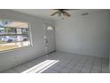 Bright living room featuring tile floors, a ceiling fan, and a front door with decorative window at 4017 W Nassau St, Tampa, FL 33607