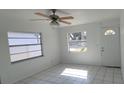 Bright living room with white-painted walls, tile floors, a ceiling fan and natural light at 4017 W Nassau St, Tampa, FL 33607
