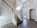 Inviting foyer with high ceilings, staircase, and decorative glass front door at 4132 Woods Rider Loop, Odessa, FL 33556