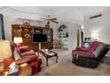 Spacious living room with ceiling fan, built-in shelving, comfortable seating, and neutral carpet at 6303 23Rd N St, St Petersburg, FL 33702