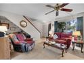 Inviting living room with neutral carpet, ceiling fan, and staircase leading to the upper level at 6303 23Rd N St, St Petersburg, FL 33702