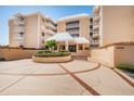 Inviting entrance to the beachfront condominium with well-maintained landscaping and a circular driveway at 6500 Sunset Way # 202, St Pete Beach, FL 33706