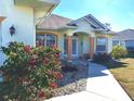 Charming home entrance with decorative columns and colorful flowerbeds at 9350 Gulfstream, Englewood, FL 34224