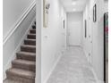 Bright hallway featuring modern tile flooring, clean white walls, and a staircase on the left at 1034 Grantham Dr, Sarasota, FL 34234