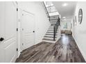 Spacious foyer featuring hardwood floors, a staircase with iron railings, and modern lighting at 1118 S Moody Ave, Tampa, FL 33629
