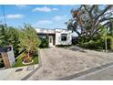 Charming home featuring modern brickwork, wood accents, neat landscaping, and a stylish brick driveway at 3106 Lila St, Tampa, FL 33610