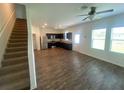 Open-concept living area with modern flooring, ceiling fan, and adjacent kitchen at 35220 White Water Lily Way, Zephyrhills, FL 33541