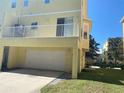 View of the garage with a balcony in a multi-story yellow condo building at 415 Bayou Village Dr, Tarpon Springs, FL 34689