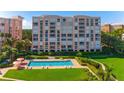 Beautiful exterior view of updated condominiums, lush landscaping, and sparkling community pool at 4951 Bacopa S Ln # 103, St Petersburg, FL 33715