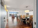 Elegant dining room with modern lighting, wood floors, and seamless flow to outdoor balcony views at 500 Treasure Island Cswy # 308, Treasure Island, FL 33706