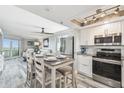 Bright, open kitchen with stainless appliances, a dining area, and views to the living area at 5915 Sea Ranch Dr # 703, Hudson, FL 34667