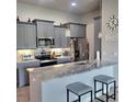 Modern kitchen features stainless steel appliances, granite countertops, and stylish grey cabinetry at 6421 Banyan Blvd # 302, New Port Richey, FL 34652