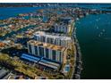 Wide aerial view of waterfront condos surrounded by boats, homes, and clear blue water at 690 Island Way # 404, Clearwater Beach, FL 33767