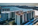 Stunning aerial view of modern condos with boat docks, coastal city, and bright blue water at 690 Island Way # 404, Clearwater Beach, FL 33767