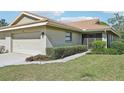 Attractive exterior of a one-story beige home with a two-car garage and lush green lawn at 7245 Wood Creek Dr # 29, Sarasota, FL 34231