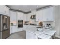 Modern kitchen with stainless steel appliances, granite countertops, and white cabinetry at 8621 Snowfall St, Sarasota, FL 34241
