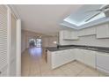 Bright kitchen features white cabinets, skylight, and seamless access to living area at 1028 Apollo Beach Blvd # 13, Apollo Beach, FL 33572