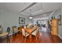 Open dining room with hardwood floors, modern light fixture, and seamless flow to the cozy living area at 1030 Bellasol Way # 302, Apollo Beach, FL 33572