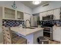 Bright kitchen with stainless steel appliances, a center island and a blue tile backsplash at 10764 70Th Ave # 2110, Seminole, FL 33772