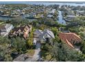 Aerial view of a stunning home surrounded by lush landscaping and situated on a canal with easy access to the bay at 1724 Amberwynd W Cir, Palmetto, FL 34221