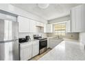 Bright kitchen featuring white cabinets, stainless steel appliances, and marble countertops at 1801 E Mcberry St, Tampa, FL 33610