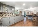 Spacious kitchen featuring grey cabinets, a tile backsplash, modern appliances and an eat-in island at 1904 Pepperwood Pl, Brandon, FL 33510
